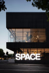Modern building with a large 'SPACE' sign at night
