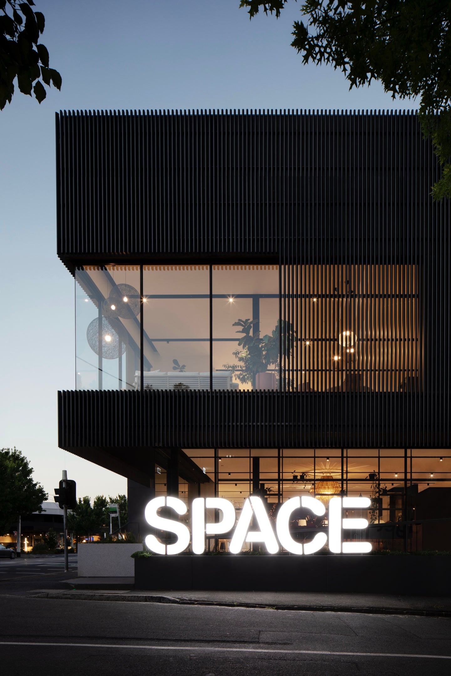 Modern building with a large 'SPACE' sign at night
