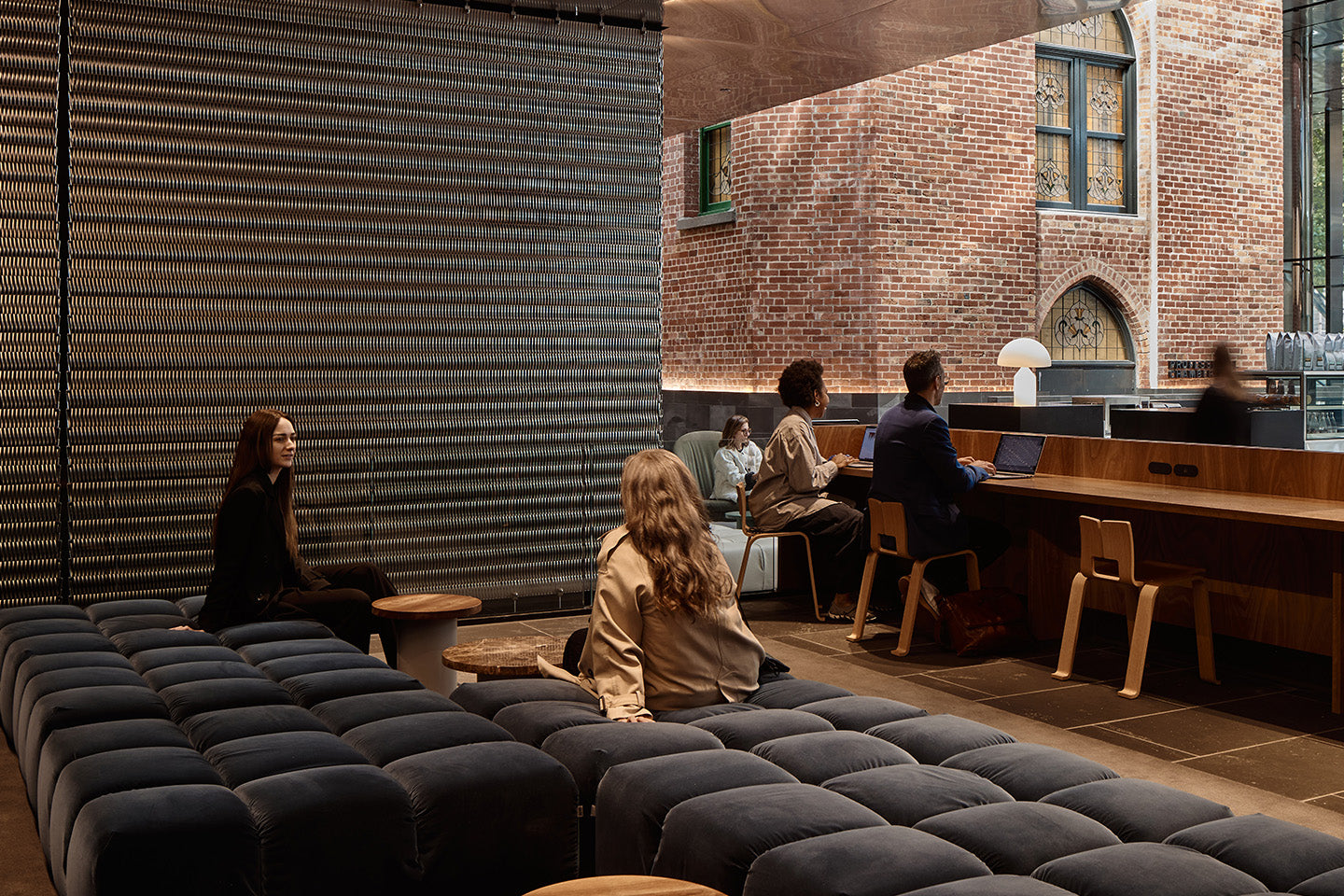 Relaxing on the mezzanine space with views to surrounding historic buildings, here B&B Italia Tufty-Time in soft grey velvet provides a place to relax and catch up with friends or colleagues. Photography © Peter Bennetts c/o Hassell.
