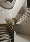 The main stair is placed quietly along the edge of the house, its open treads and textural materials softly bouncing light through the space.
